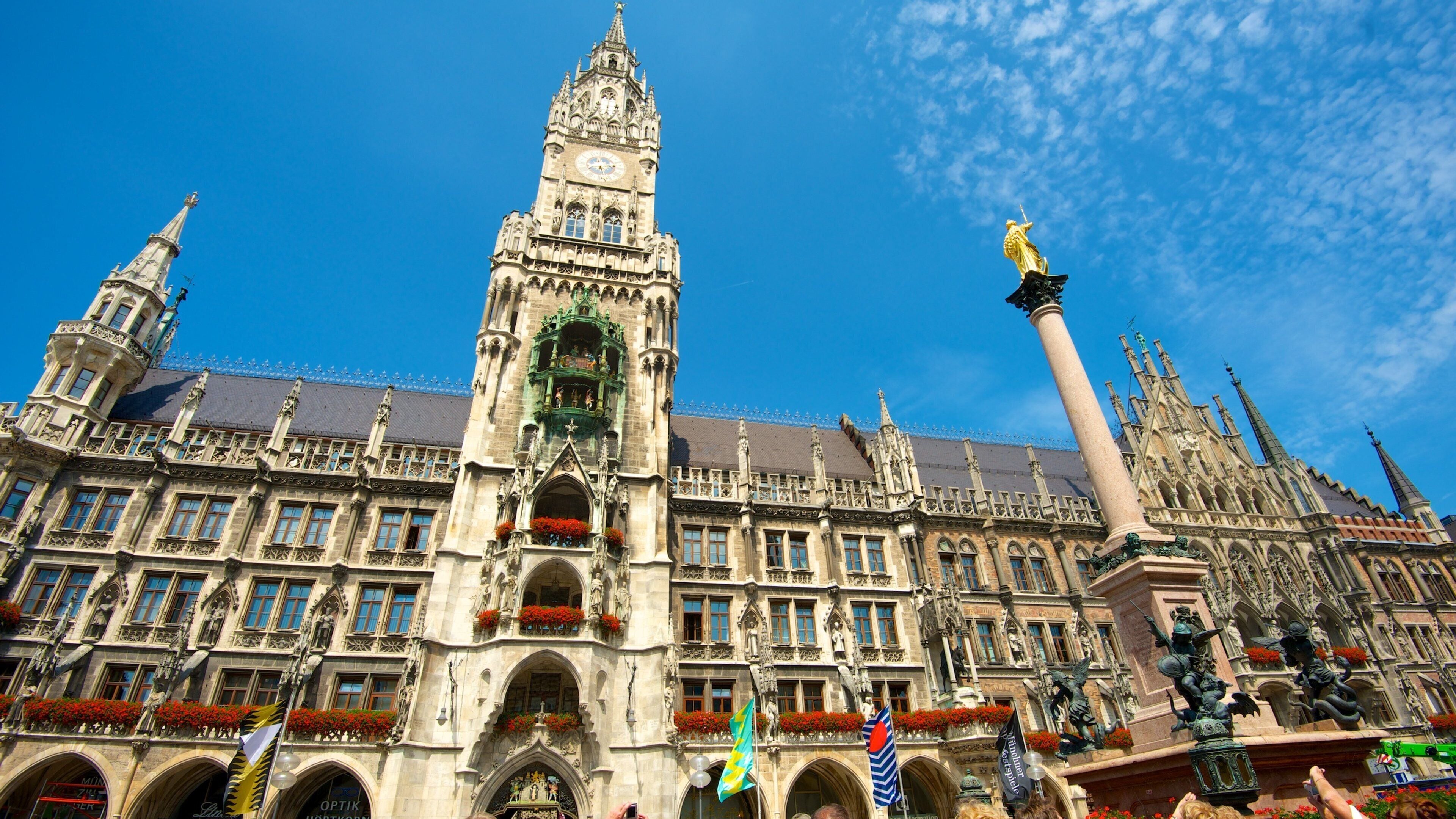 A historic building with ornate architecture, a prominent clock tower, and statues.
