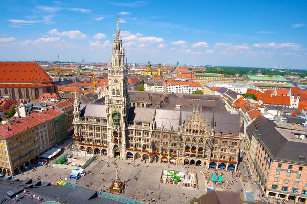 Ein historischer Stadtplatz mit einem markanten Dom, umgeben von bunten Gebäuden und blauem Himmel.