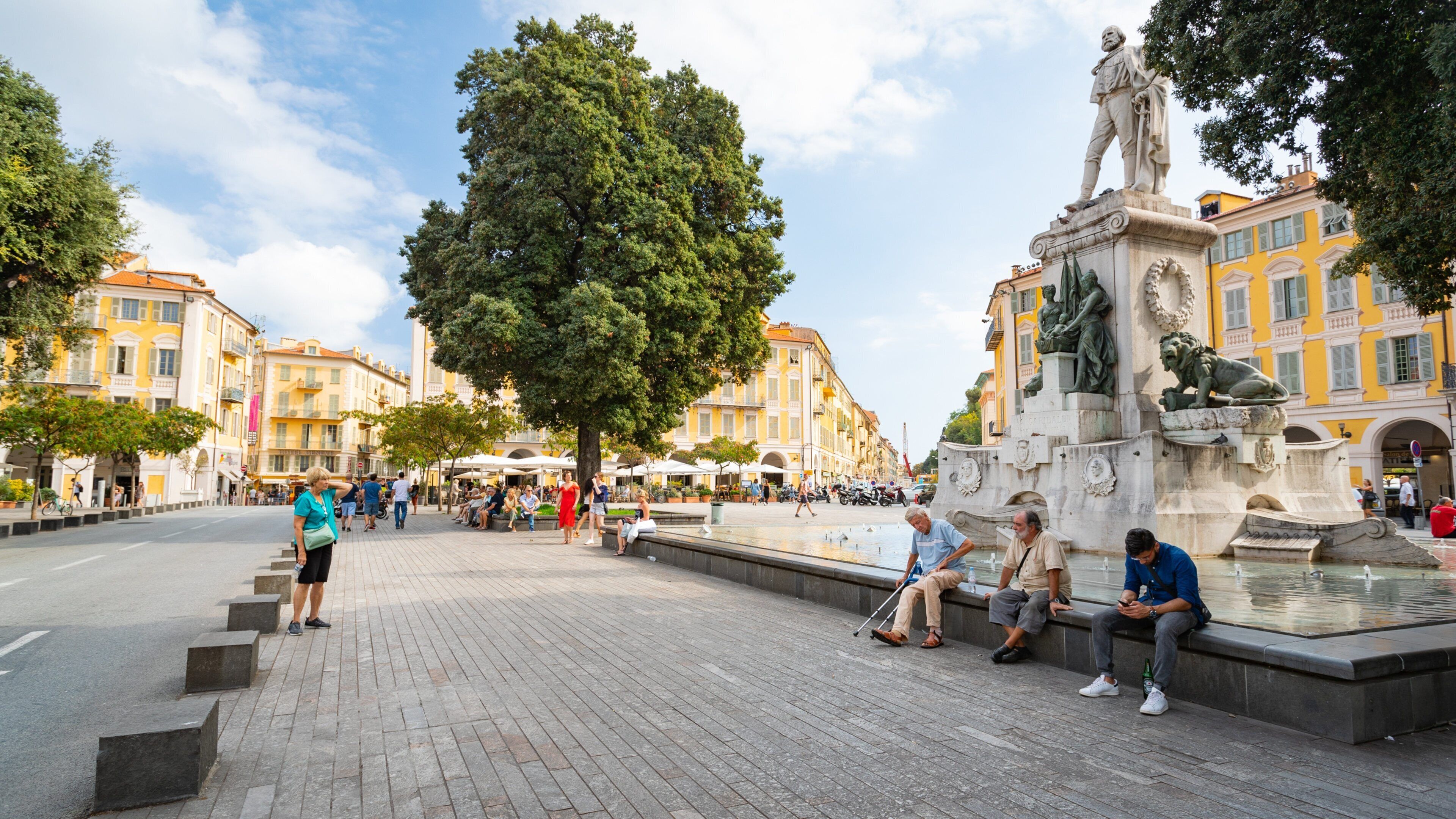 Place Garibaldi featuring a statue or sculpture and a fountain as well as a small group of people