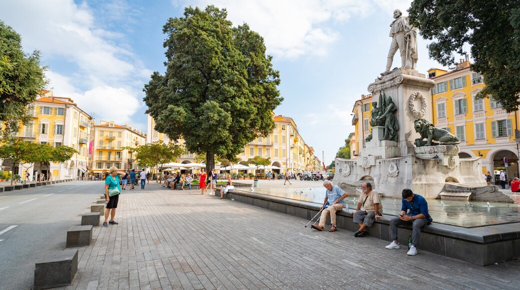 Place Garibaldi featuring a statue or sculpture and a fountain as well as a small group of people