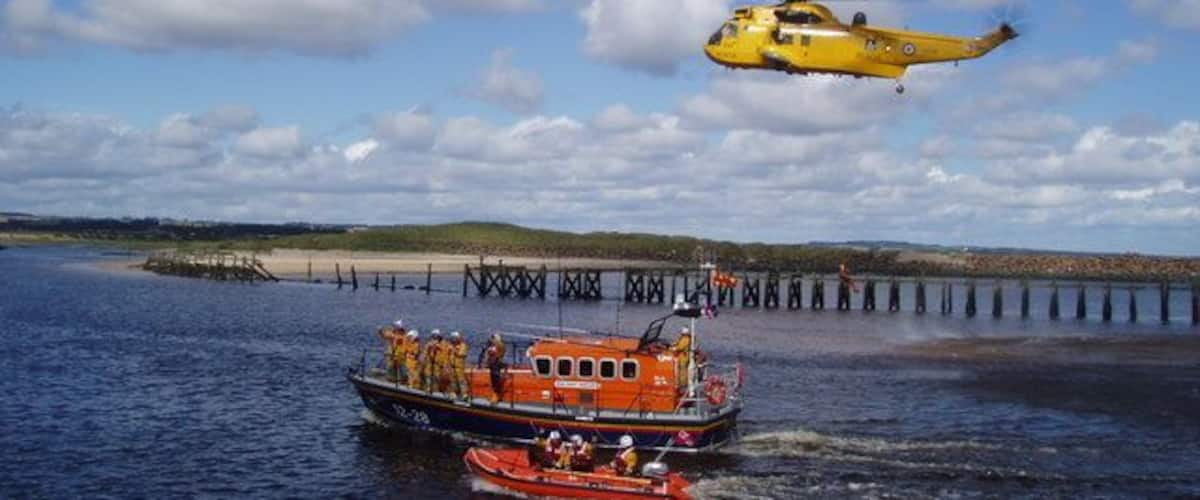 Lifeboat Day, Amble Amble Lifeboat Crew and the helicopter rescue team from RAF Boulmer demonstrate their lifesaving skills. The disused North jetty of Warkworth Harbour is in the background.