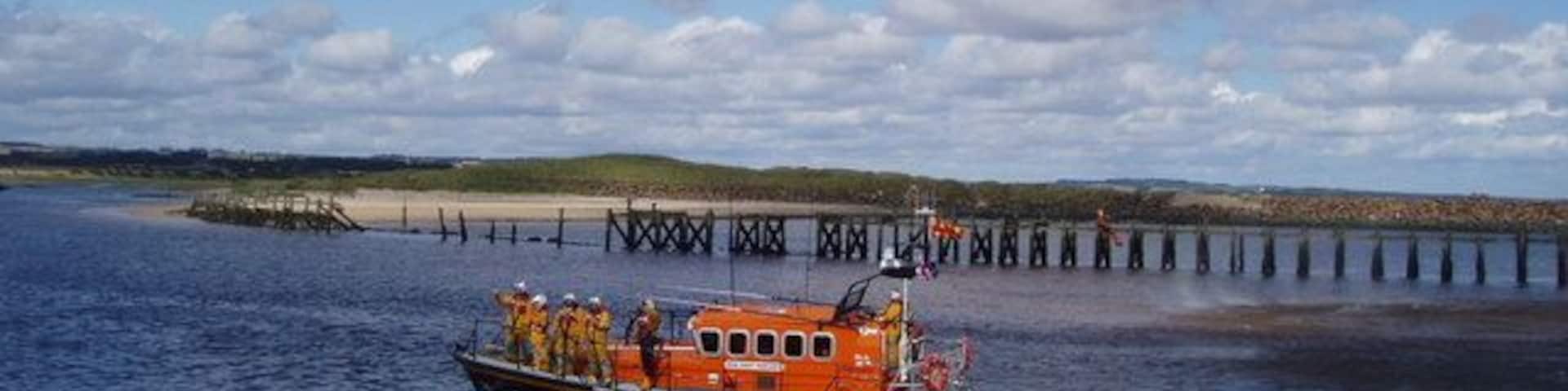 Lifeboat Day, Amble Amble Lifeboat Crew and the helicopter rescue team from RAF Boulmer demonstrate their lifesaving skills. The disused North jetty of Warkworth Harbour is in the background.
