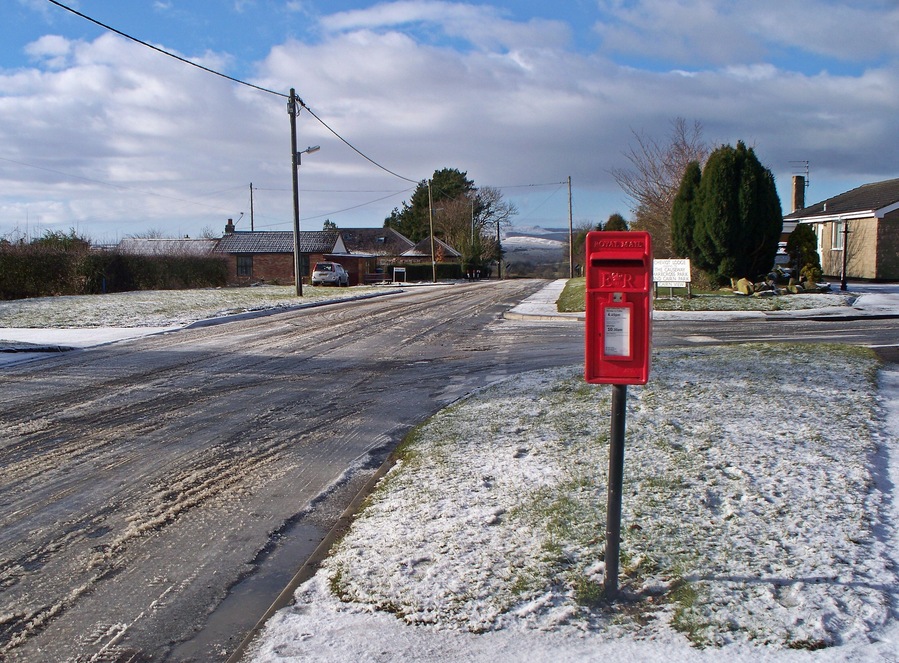 Looking West From near the junction of Rothbury Road into Cheviot Lodge. Villa Lane and West lane cottages can be seen to the left, Simonside under snow in the middle distance and No 1 Cheviot Lodge to the right.