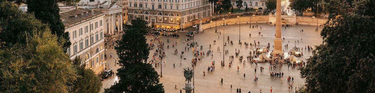 A bustling square with historic buildings, a prominent dome, and a central monument.