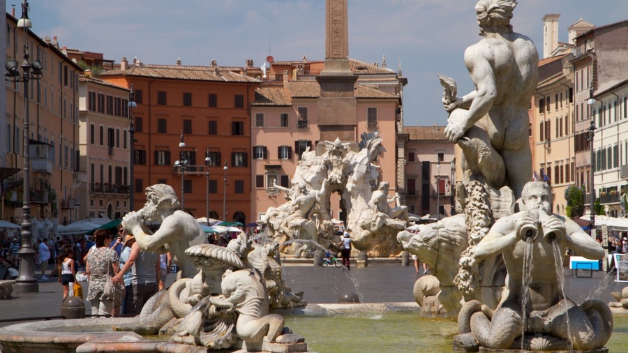 Visitors admire the fountains and architecture at Piazza Navona in Rome during a sunny day