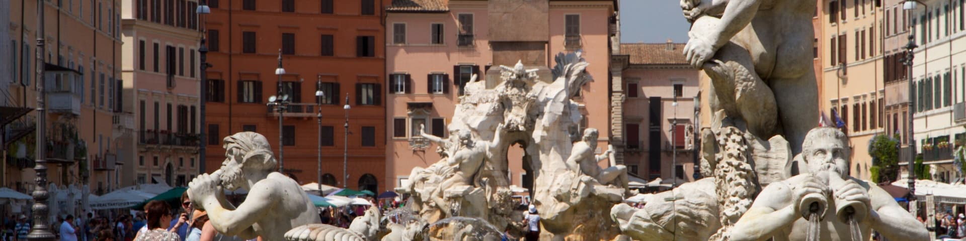 Visitors admire the fountains and architecture at Piazza Navona in Rome during a sunny day