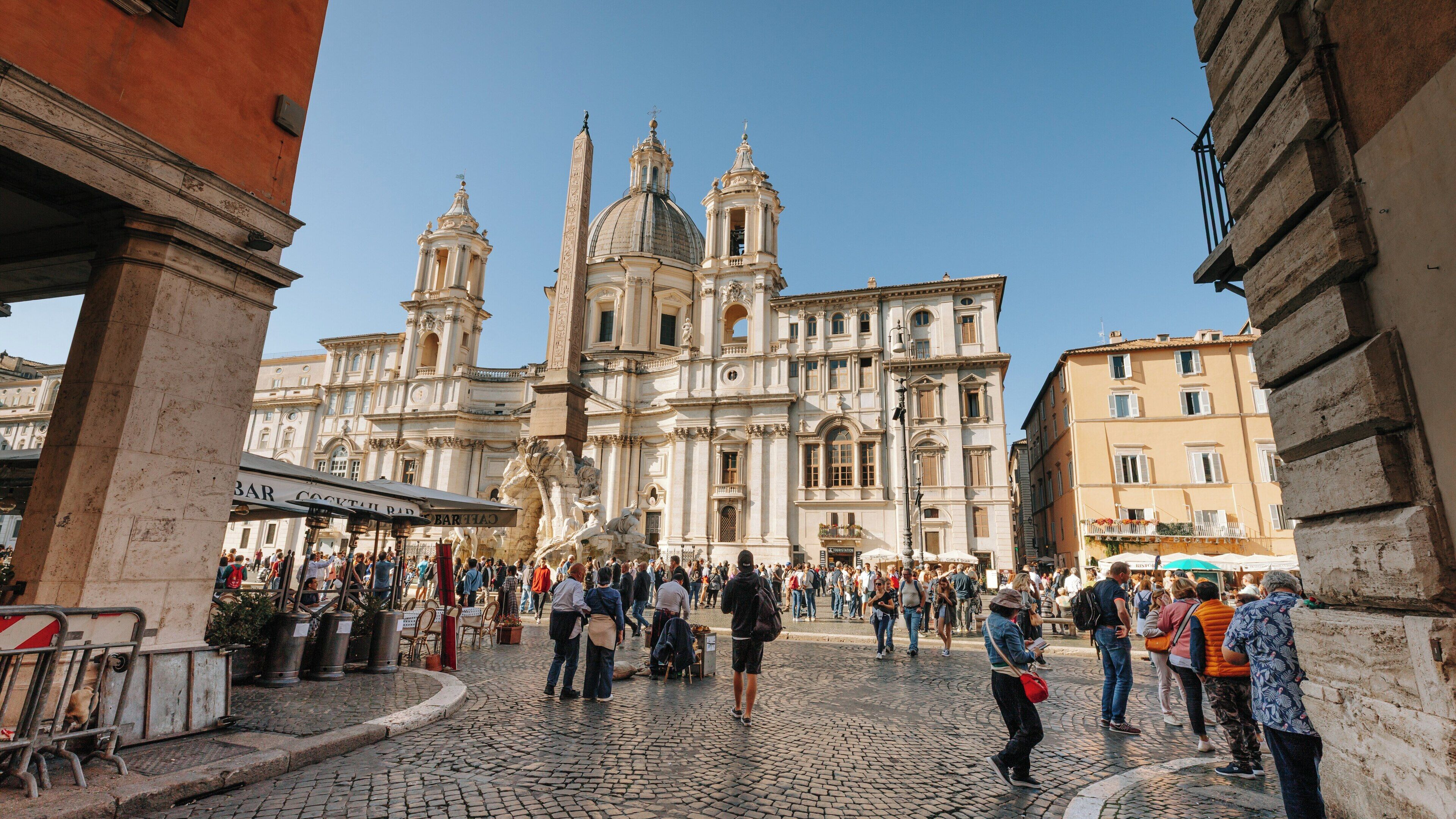 Stunning views of Piazza Navona filled with visitors enjoying the historic architecture under a clear blue sky