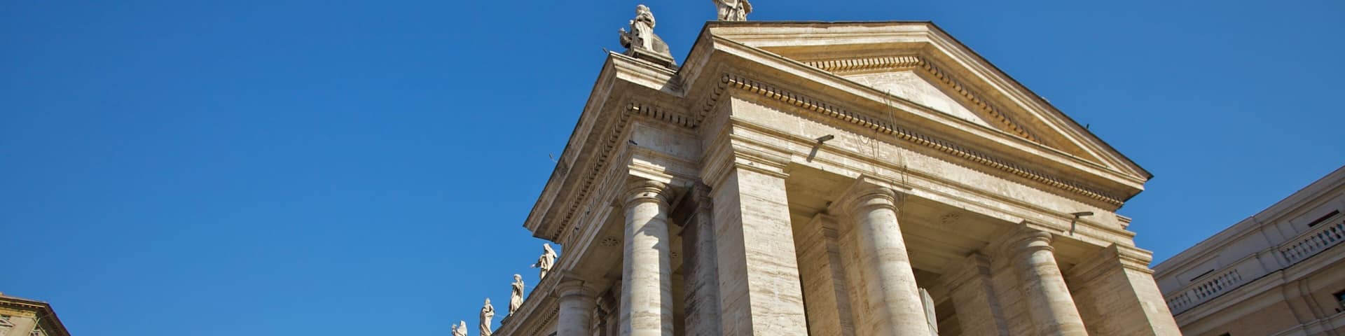 St. Peter's Square showcases its impressive architecture under a clear blue sky in Rome, Italy