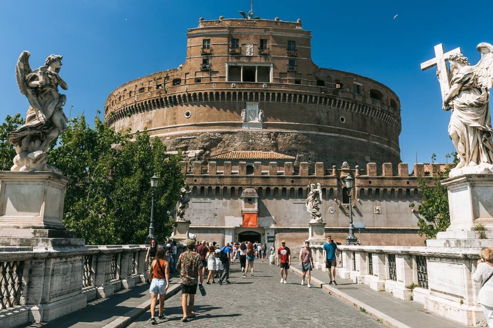 The Colosseum in Rome, Italy, with tourists walking in front.