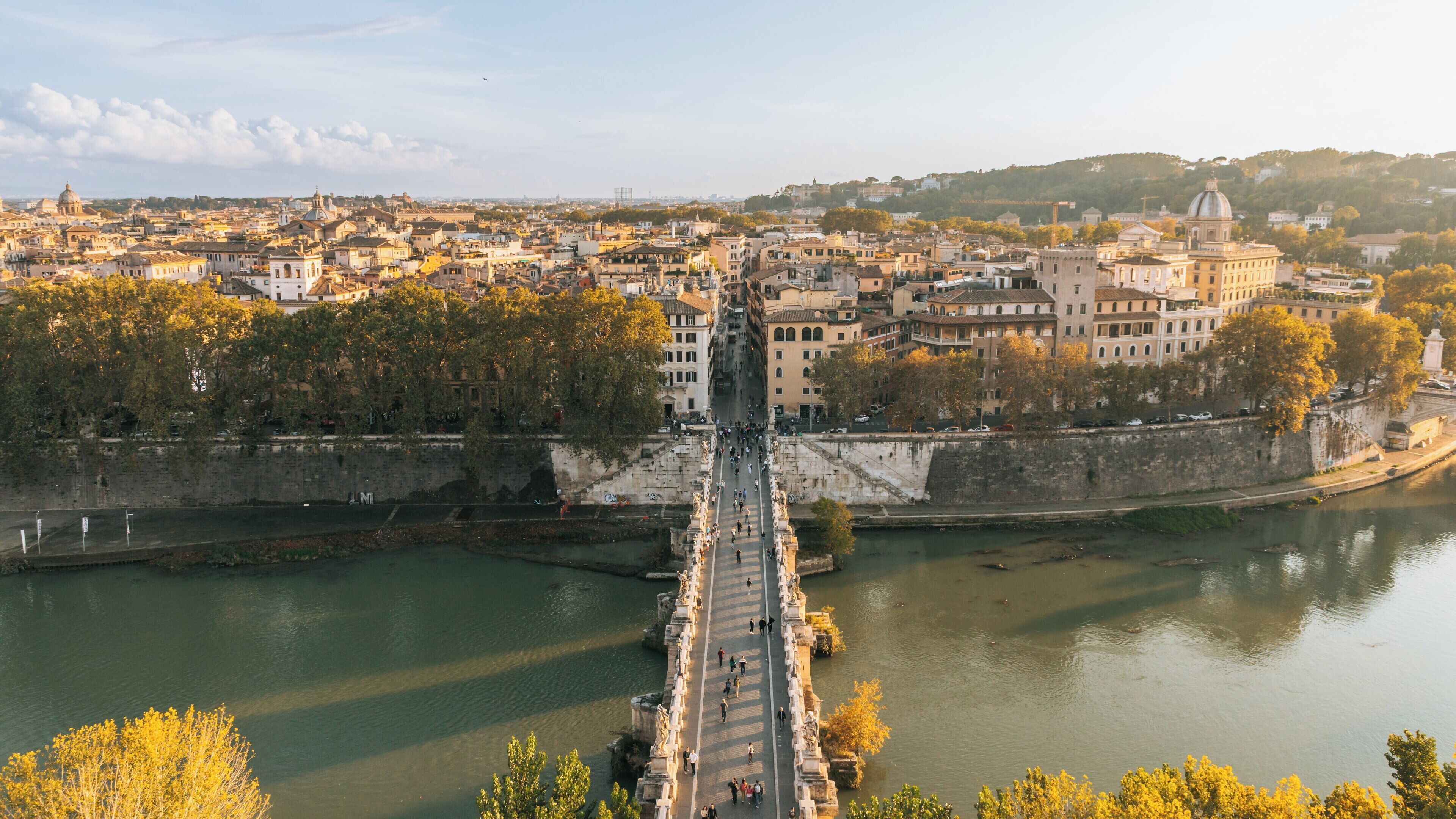 View of Ponte Sant'Angelo in Rome, showcasing the historic architecture and vibrant atmosphere during sunset
