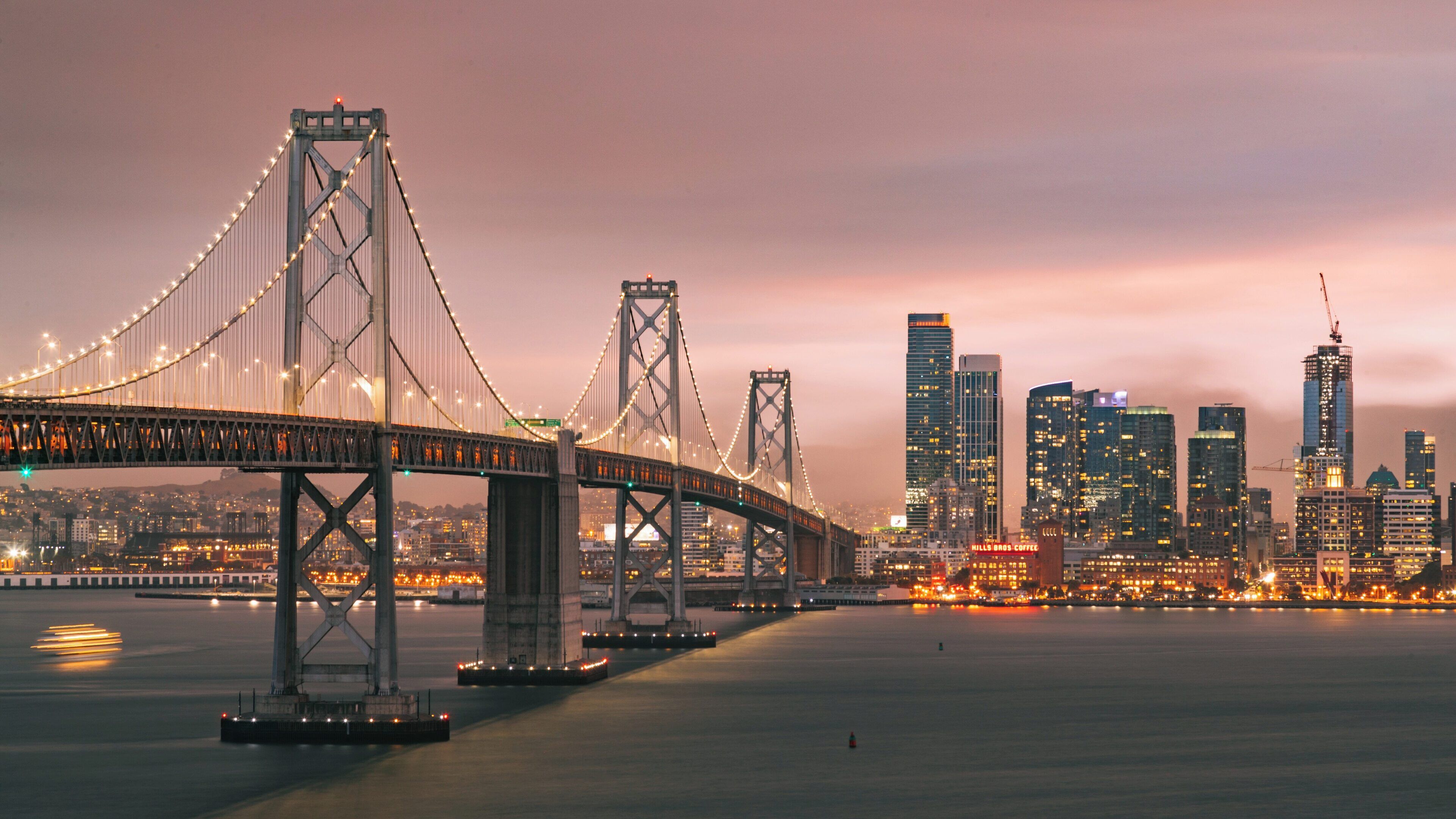 Bay Bridge illuminated at twilight with Downtown San Francisco skyline in the background