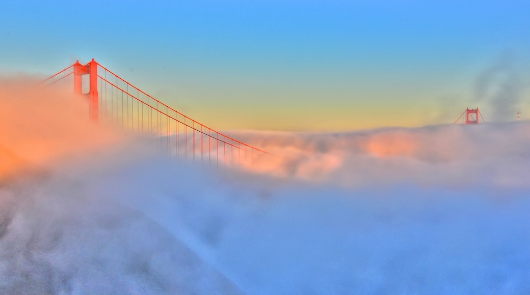 Golden Gate Bridge rises above fog at sunrise in San Francisco Bay area California