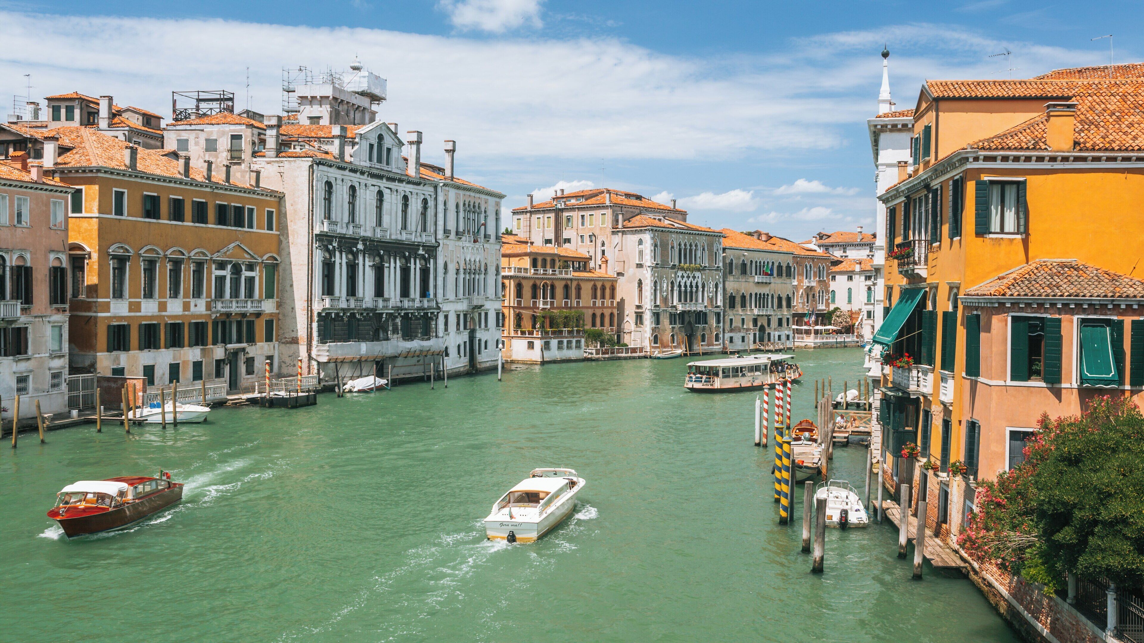 Admiring the serene waters and historic architecture near Academy Bridge in Venice City Center during a bright sunny day