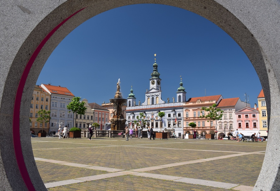 A historic square with a prominent church, a fountain, and colorful buildings.