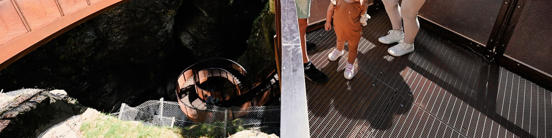Mother with children stand in metal stairs in Liechtensteinklamm or Liechtenstein Gorge, Austria.