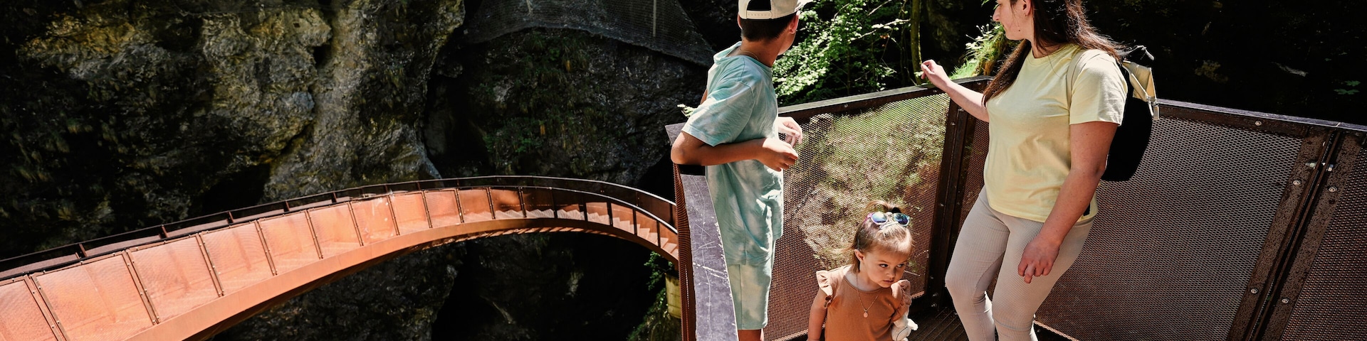A bridge over a rocky gorge with a spiral staircase descending into the gorge.