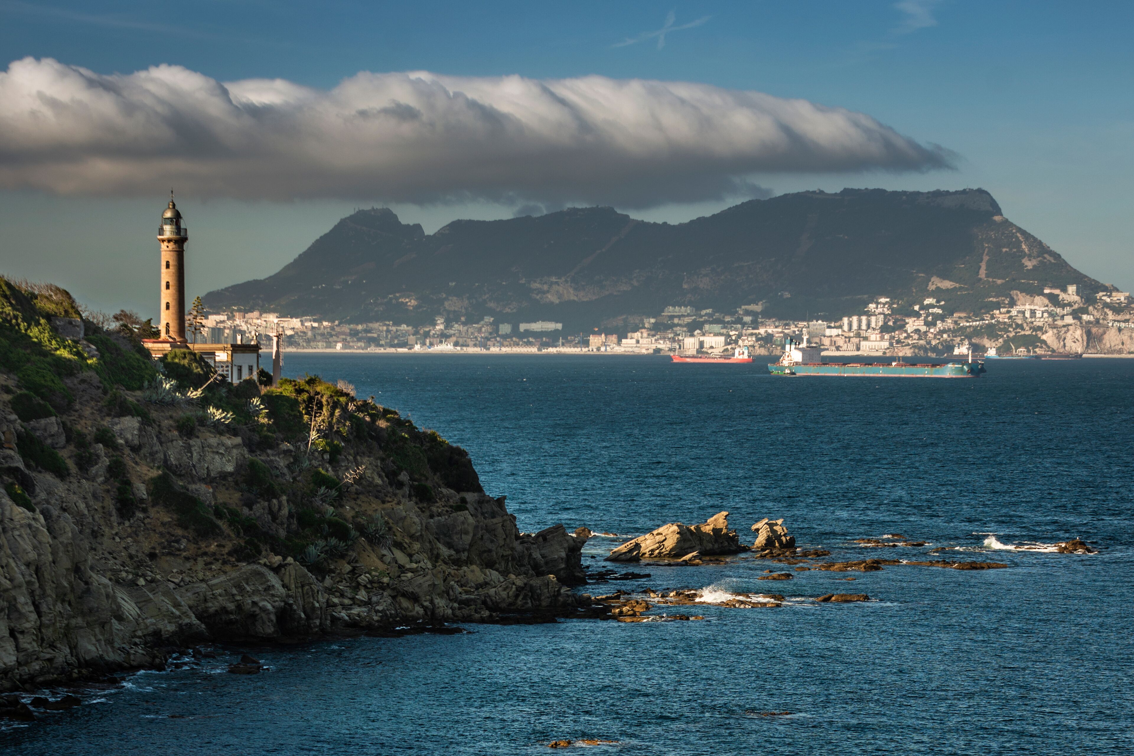 Punta Carnero lighthouse with Rock of Gibraltar in the distance, Cadiz, Andalusia, Spain