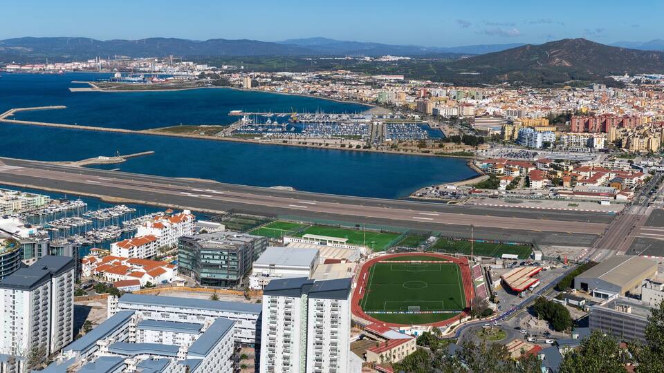 A coastal city with a marina, airport, and residential buildings.
