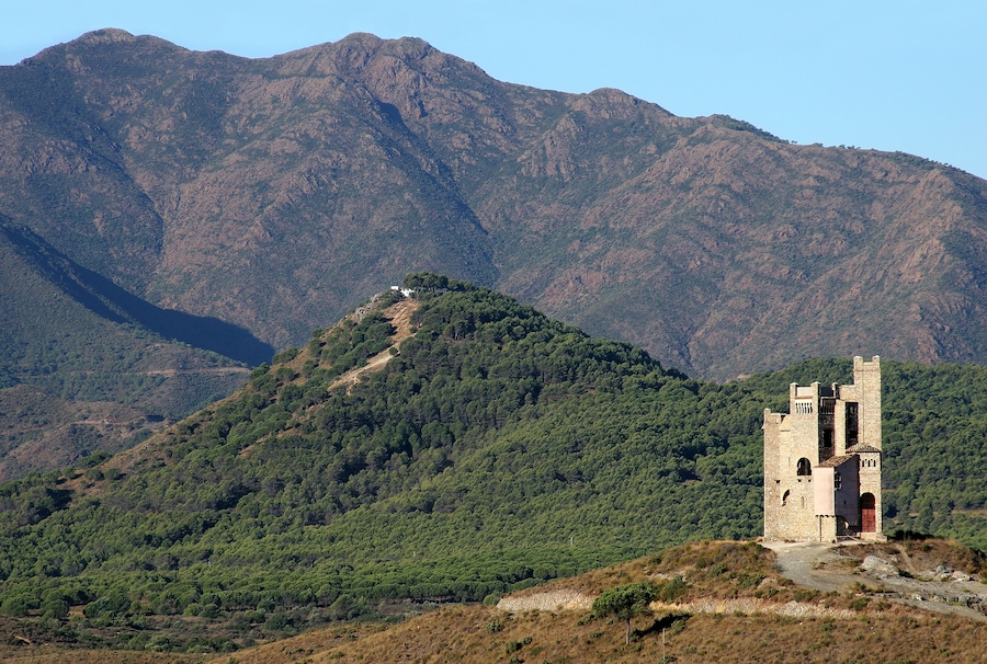 Ancient Moorish water tower and mountain backdrop in Alhaurin on the Costa del Sol in Spain