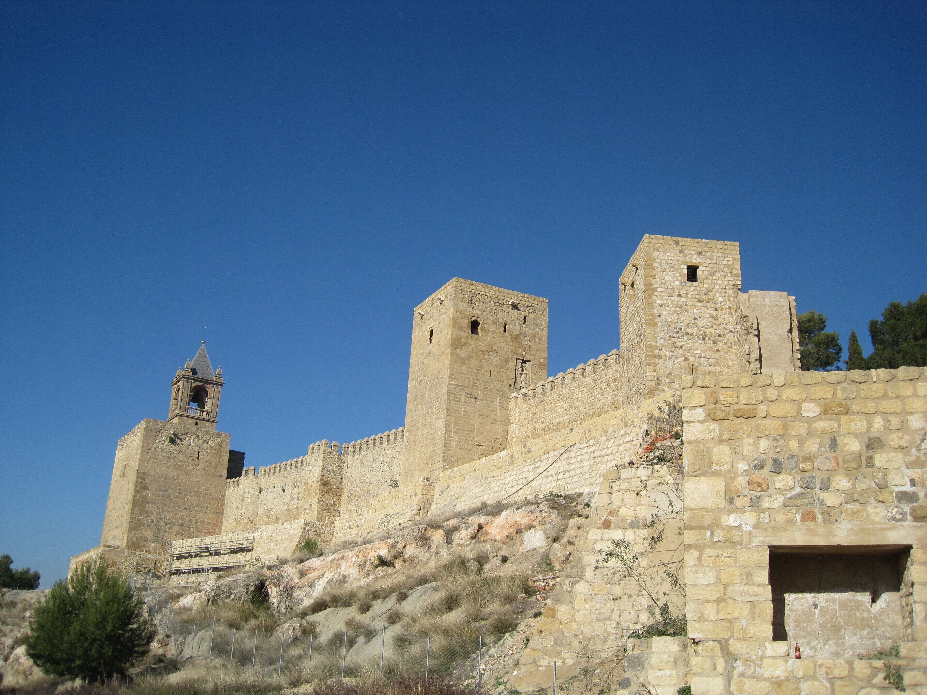A historic stone fortress with a prominent bell tower and crenellated walls.