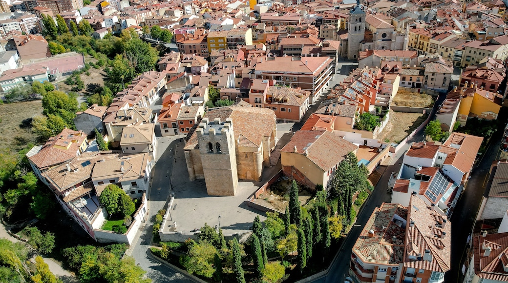 Luftaufnahme einer historischen Stadt mit engen Gassen, traditioneller Bebauung und einem markanten Kirchturm.