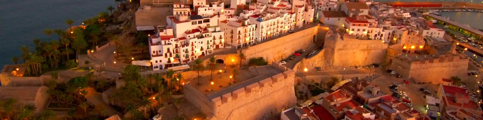 A coastal city with a prominent castle, narrow streets, and a mix of historic and modern buildings.