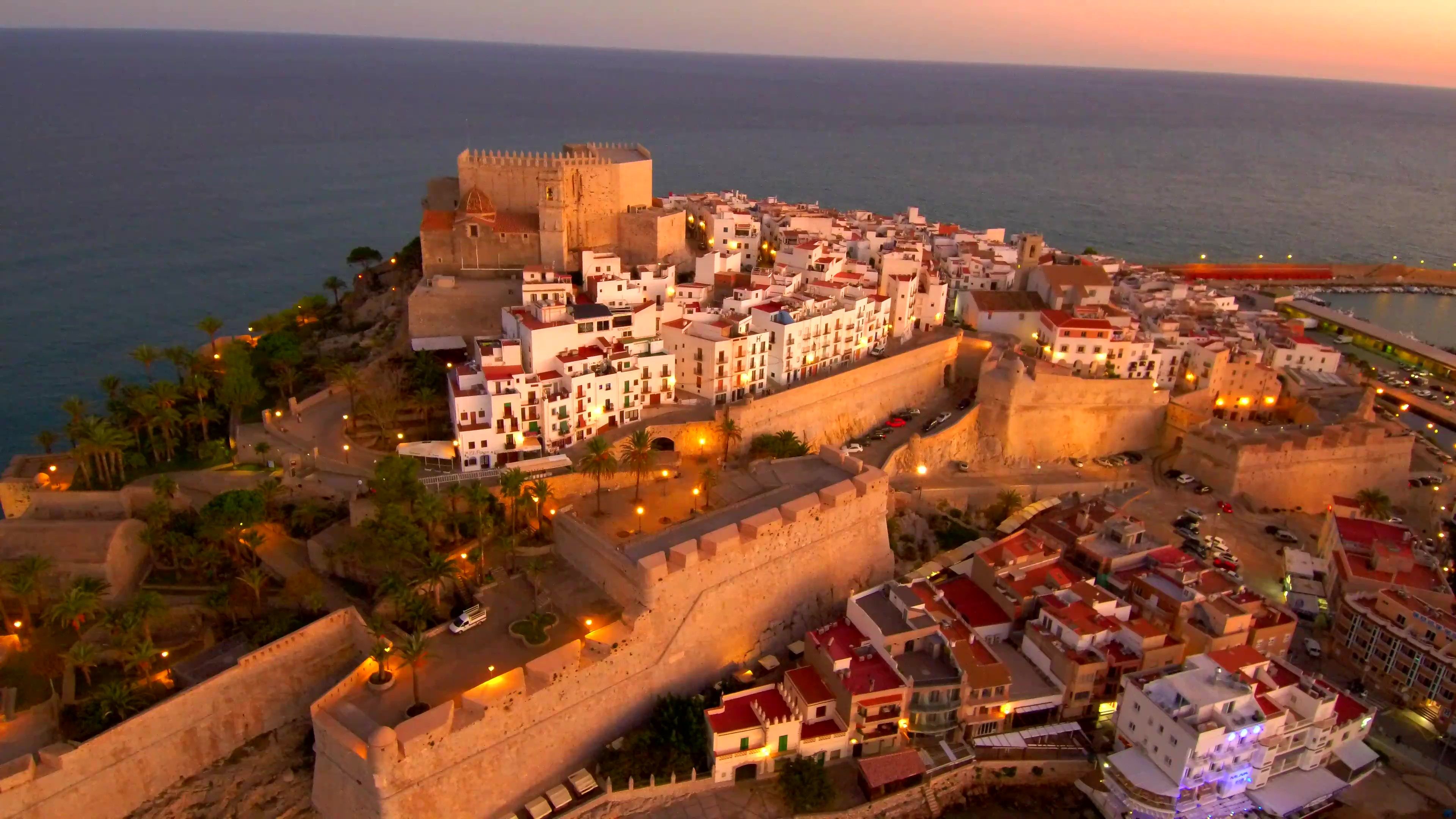 A coastal city with a prominent castle, narrow streets, and a mix of historic and modern buildings.