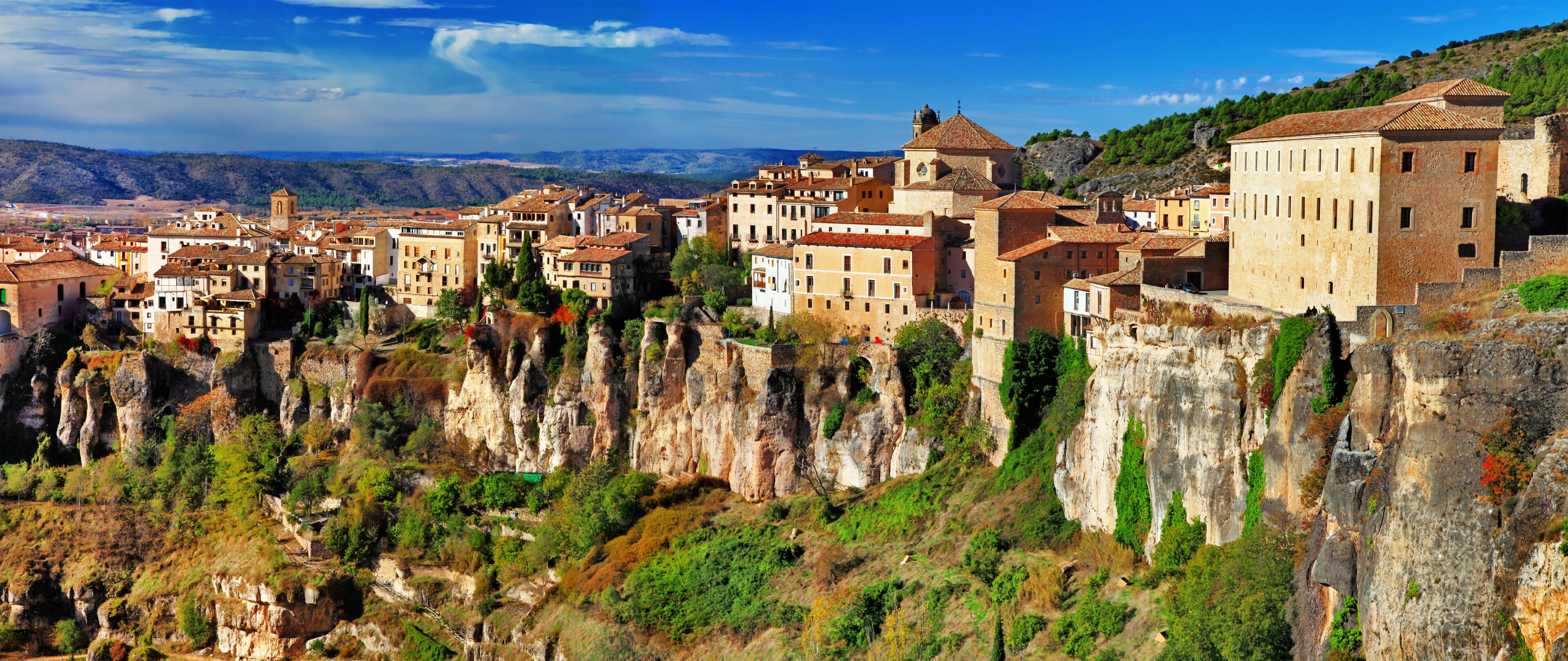 A town nestled in a valley with terraced buildings and cliffs.
