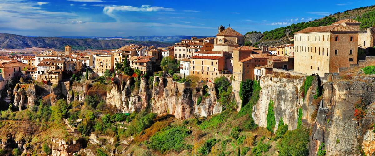 A town nestled in a valley with terraced buildings and cliffs.