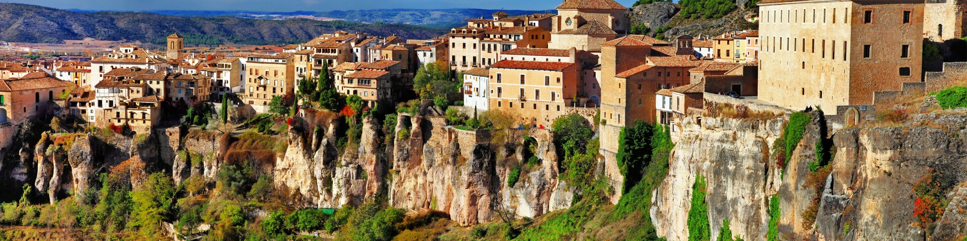 A town nestled in a valley with terraced buildings and cliffs.