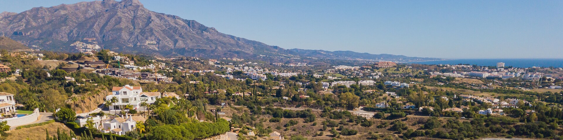 A coastal town with a prominent mountain in the background.