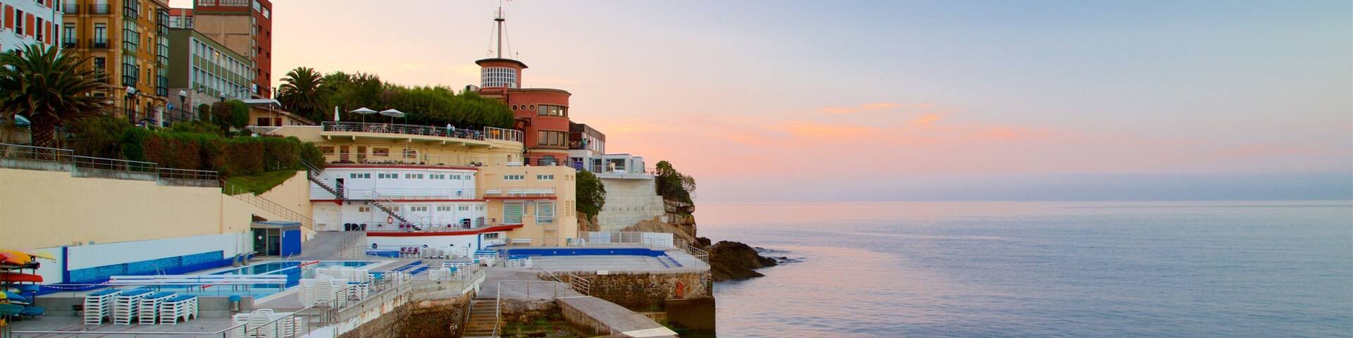 Gijon showing a coastal town, general coastal views and a sunset