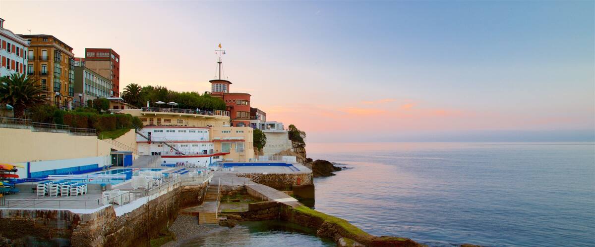 Gijon which includes general coastal views, a coastal town and a sunset