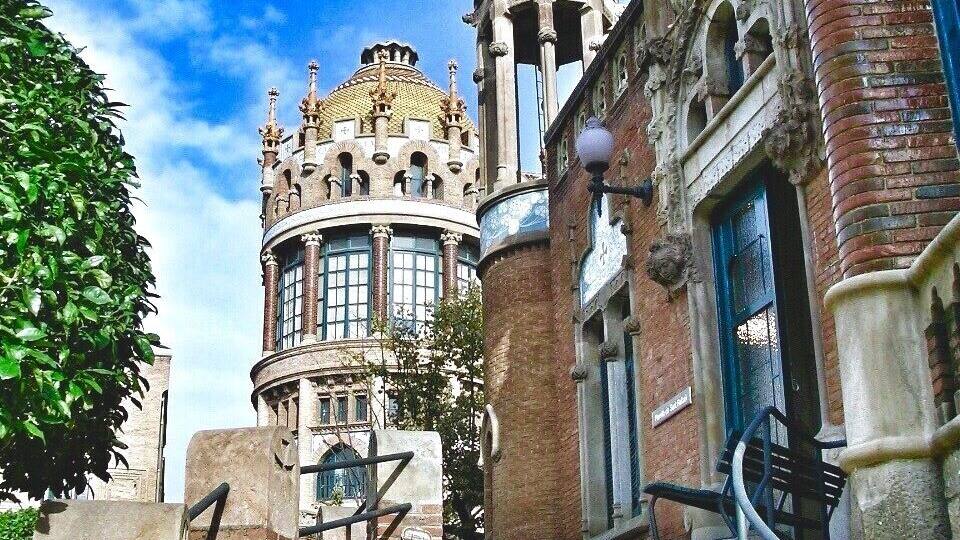 A historic building with ornate architecture, including a tower with a pointed roof and a dome.