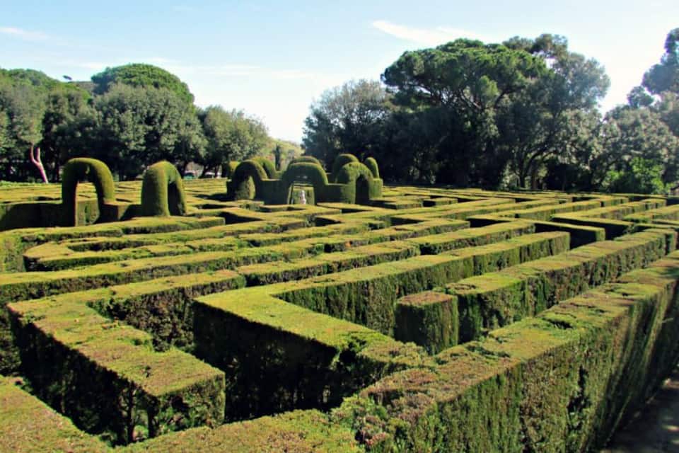 Um labirinto de sebes com sebes bem aparadas e algumas árvores esculpidas.