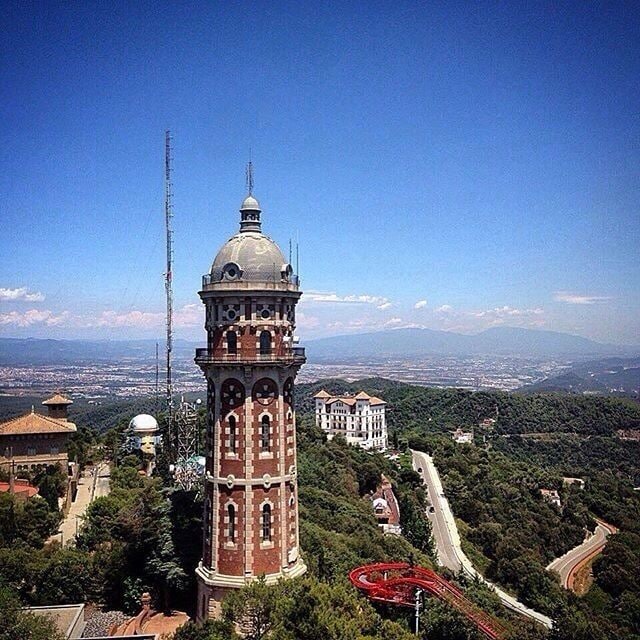 A tower with a dome and a building with a dome in the background.
