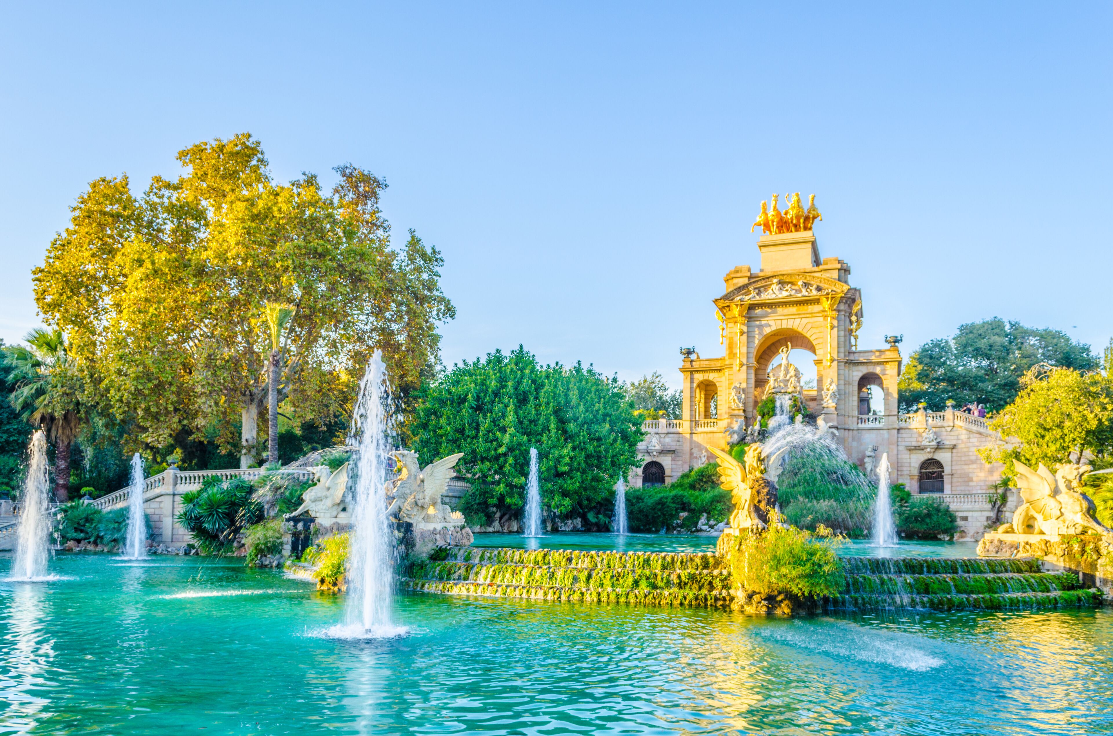A fountain, a bridge, and a historic building with statues.