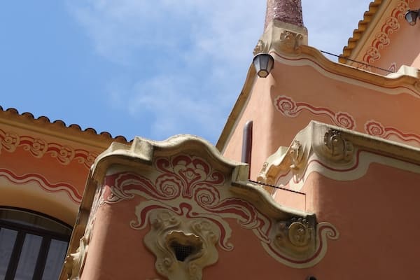 Un bâtiment doté d’éléments architecturaux raffinés, notamment une cheminée décorative et des motifs complexes sur la façade.