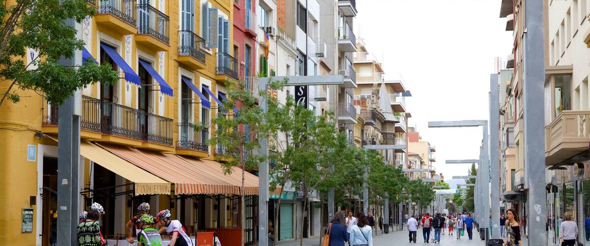 A bustling urban street lined with colorful buildings, cyclists, and pedestrians.
