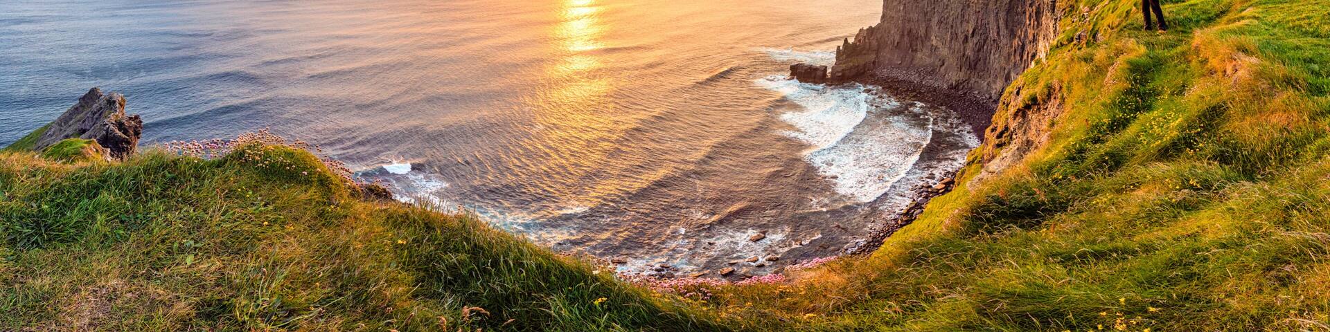 Man looking at Sunset at the Cliffs of Moher, County Clare, Munster province, Republic of Ireland, Europe.