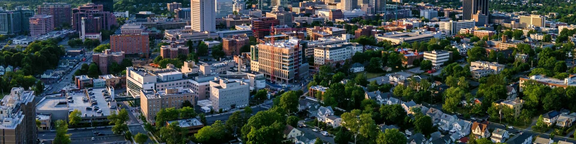 A cityscape with a mix of high-rise buildings and residential areas, surrounded by greenery.