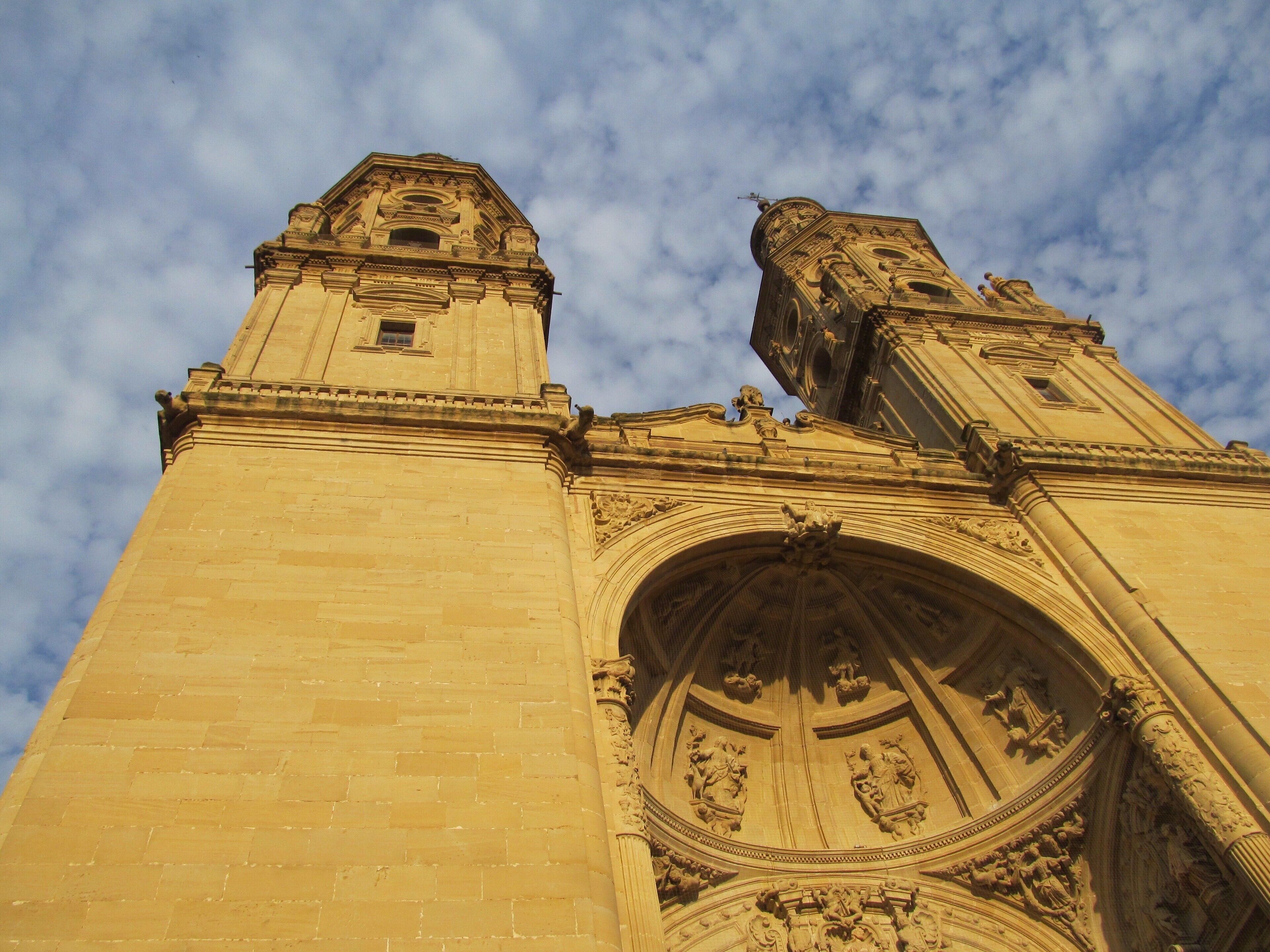 A tall, ornate building with intricate carvings and a large arched doorway.
