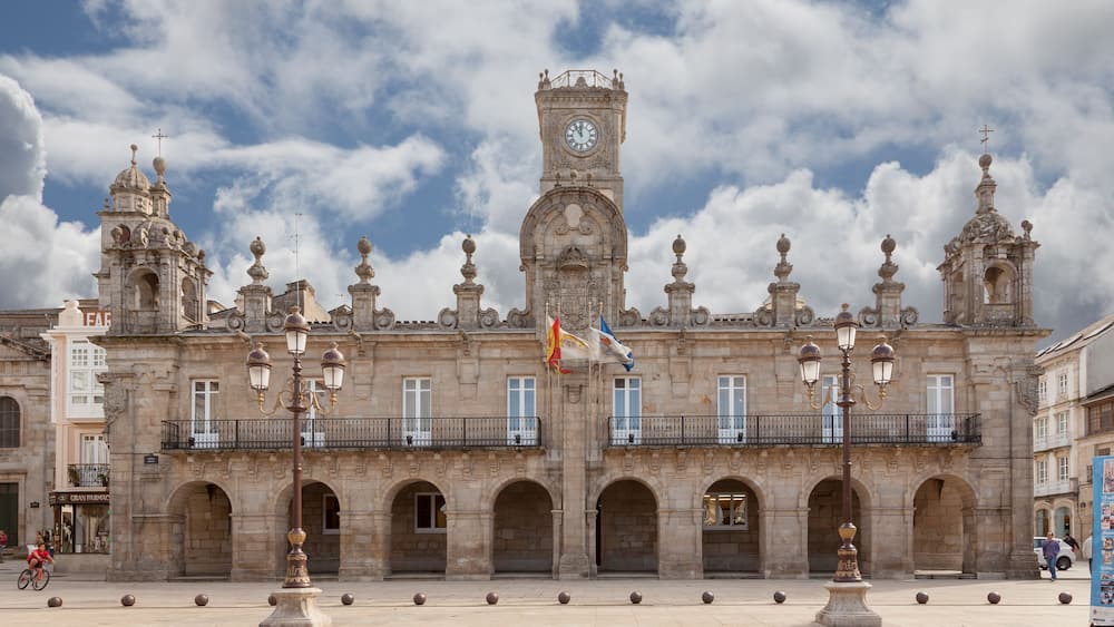 A historic building with a clock tower, arched windows, and ornate balconies.