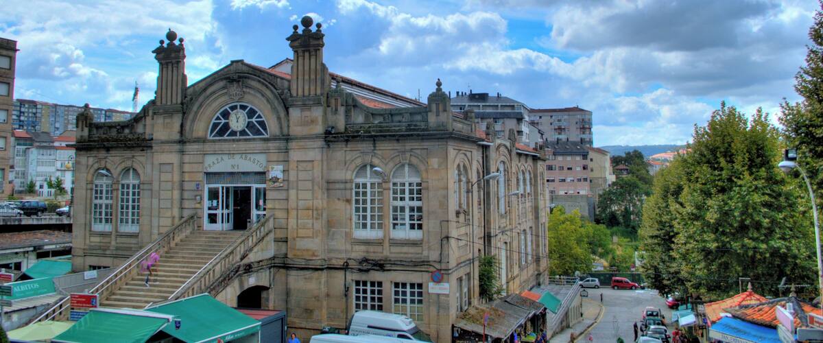 A historic building with a clock tower and a staircase leading to the entrance.