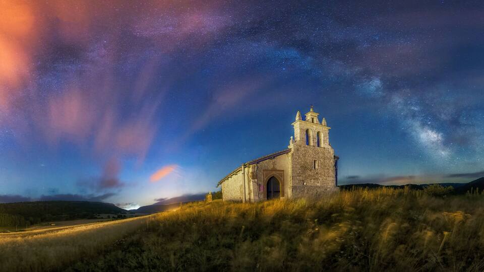 Night view of the church of San Miguel Arcangel in Villacibio, Palencia, with the arch of the Milky Way crowning the sky