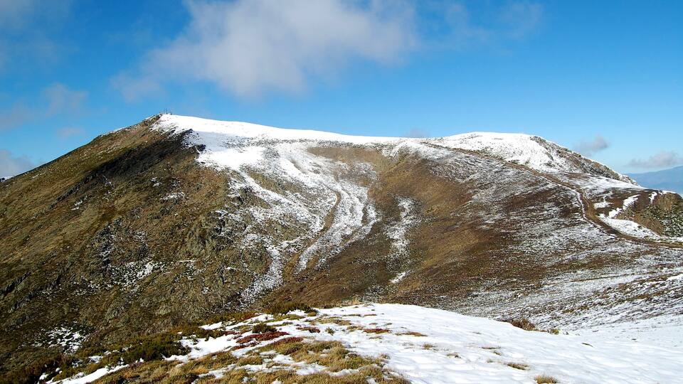 A snow-covered mountain with a clear sky.