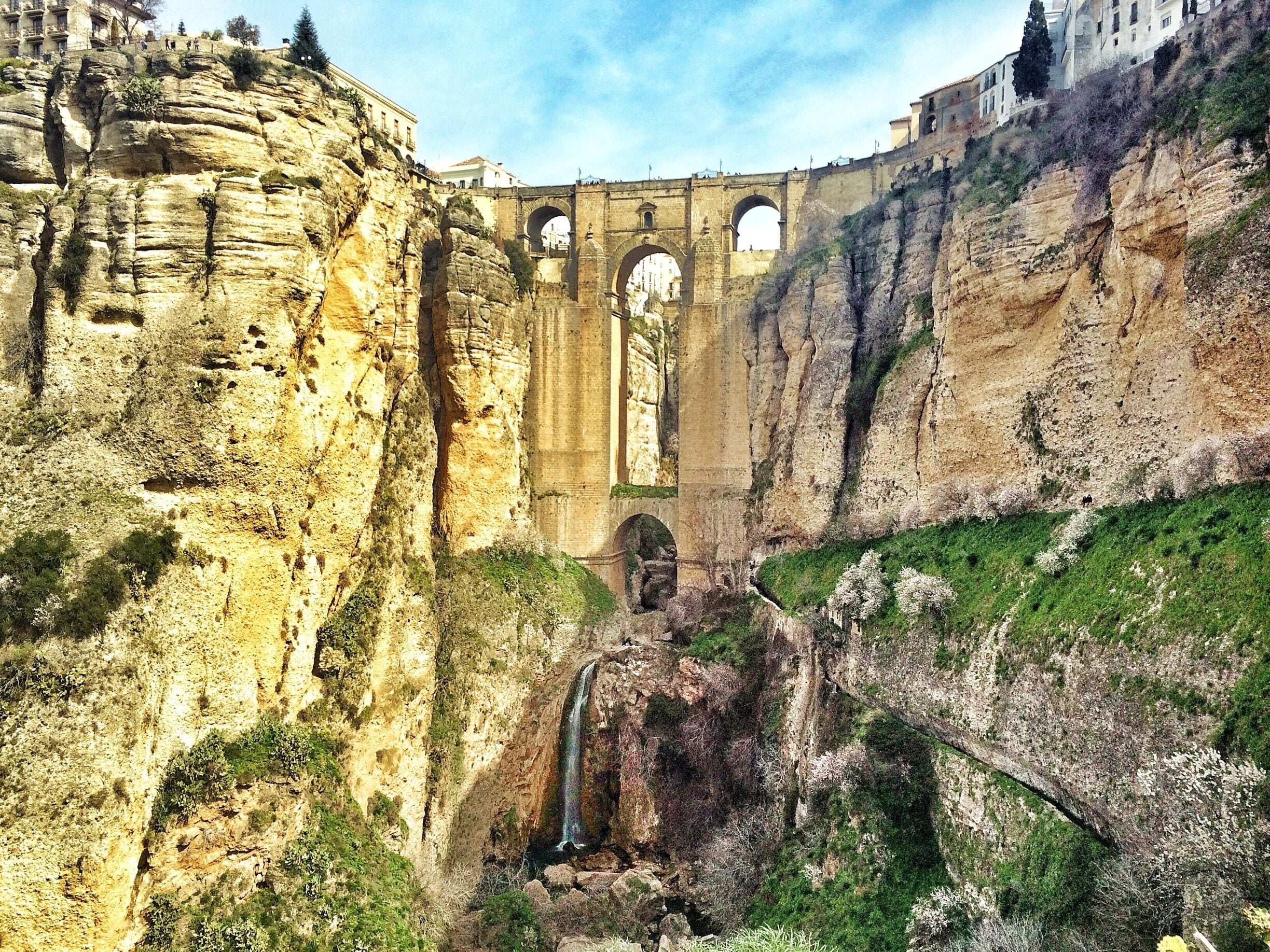 The Stone Bridge Puento Nuevo, designed by José Martín de Aldehuela, was build from 1751-1802 over the 120m deep gully El Tajo. 

After crossing the Puente Nuevo to the old town keep walking  right until you reach some stairs going downhill to get this amazing view! 
It's the only place to fully see the bridge and the waterfall! 
#architecture