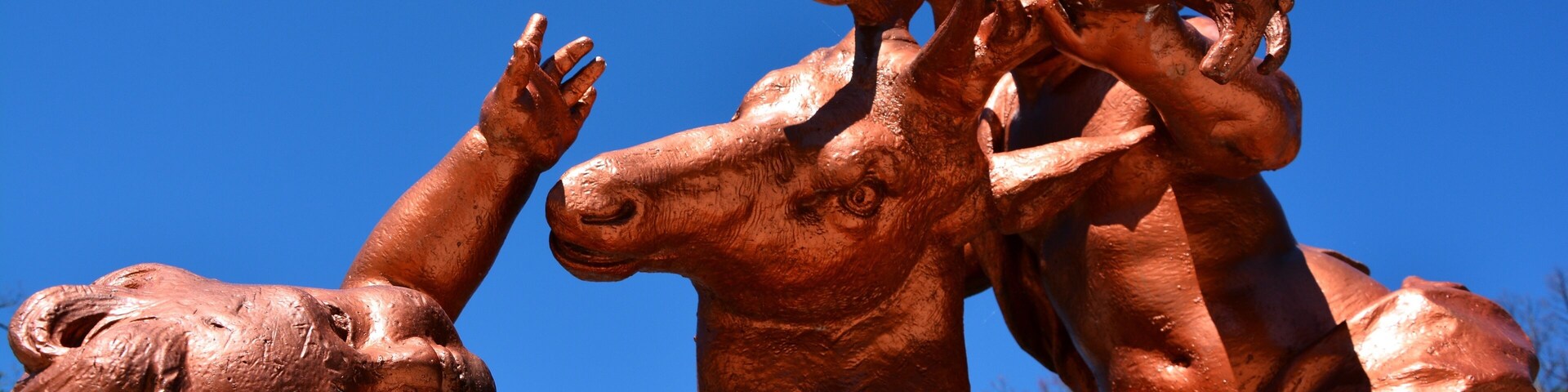 Uma escultura em bronze de um leão e um bezerro.