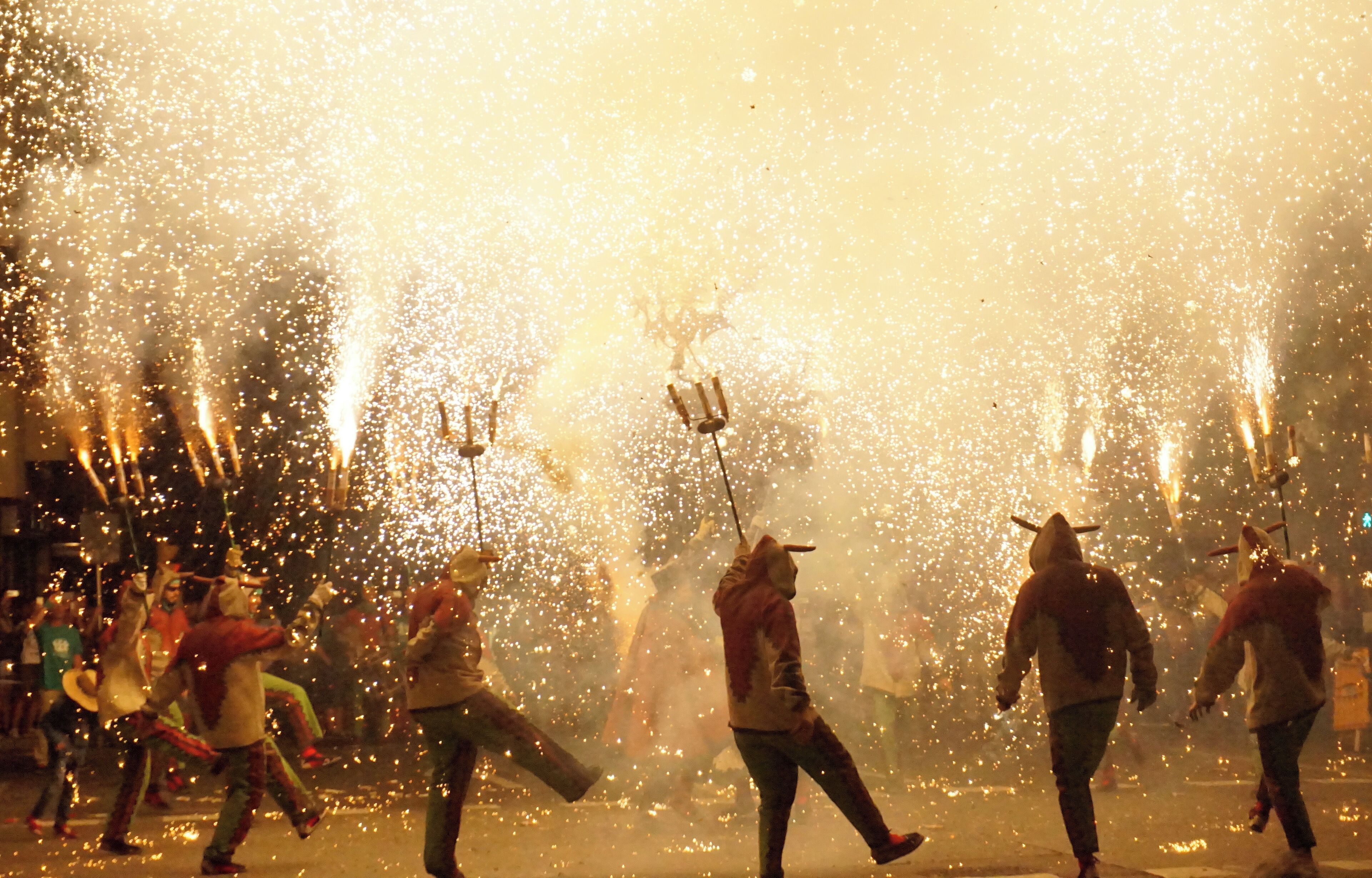 Correfocs, fire runners, are a tradition from Catalonia, Valencia, France, etc. Men, women, children run through the fireworks while dancing or playing the drums. Dressed as devils, usually there's a main character, a dragon, a demon, etc, in the center of the dance. This photo was taken in Tarragona, ancient roman Tarraco, in Catalonia. 