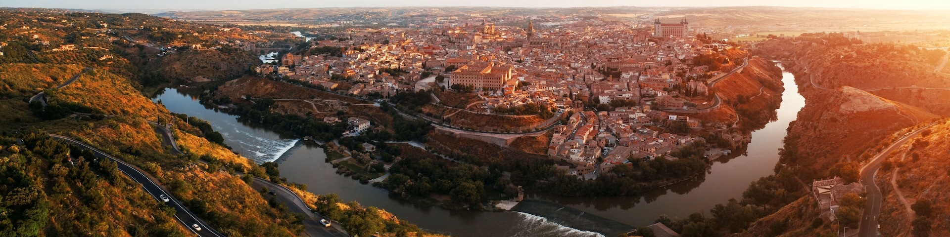 Un río serpentea por una ciudad rodeada de colinas.